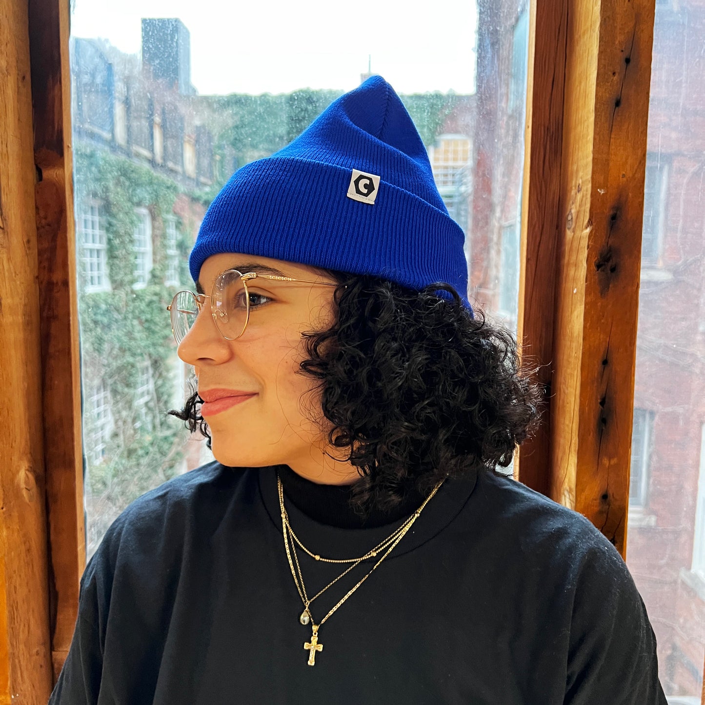 Noor wears the Canadaland toque in our signature blue, with a cheeky little smirk on her face.